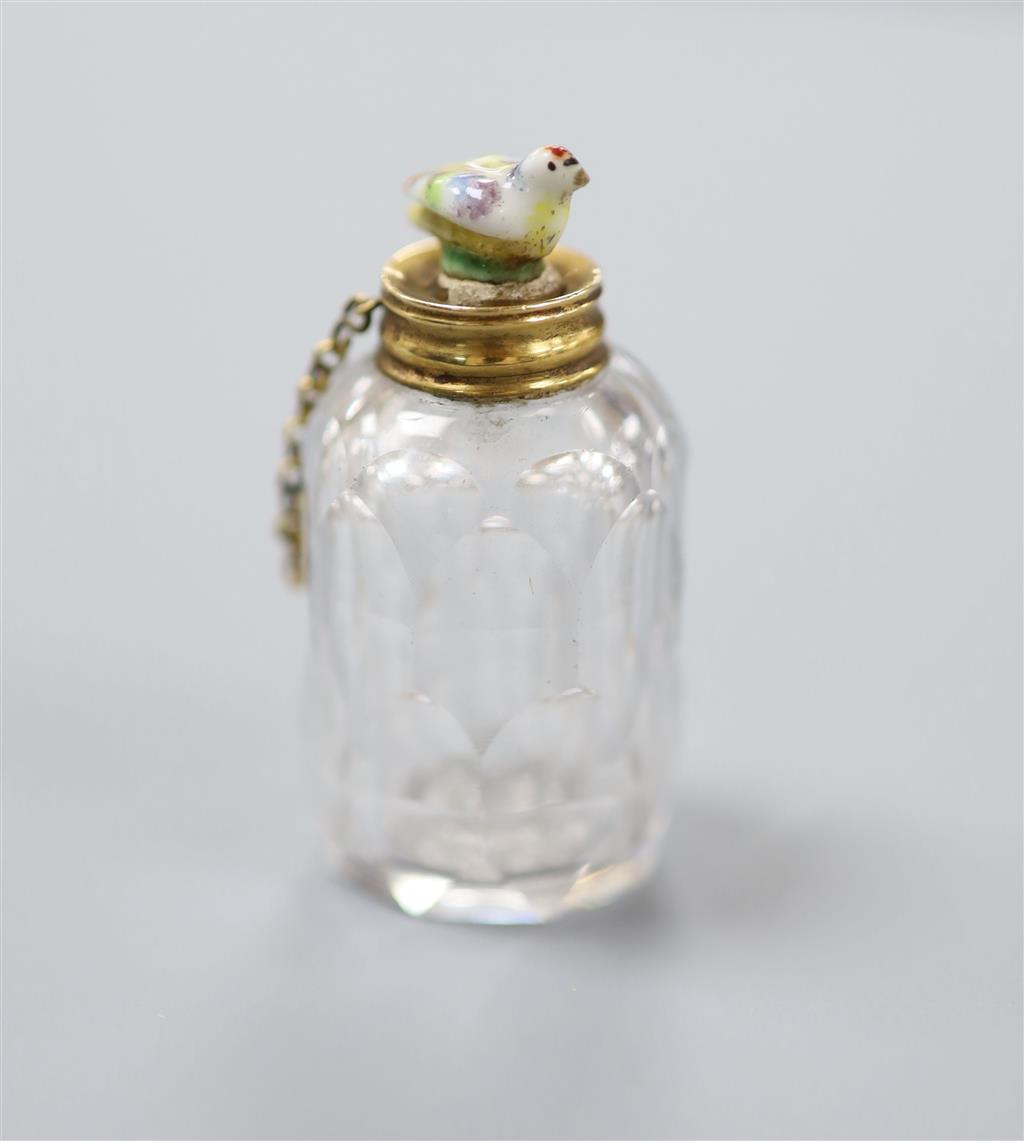 A 19th century yellow metal mounted cut glass scent bottle, with porcelain chick mounted stopper, 41mm.